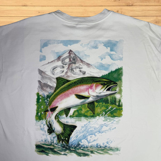 T-shirt with a graphic of a fish leaping out of water with mountains in the background on a wooden surface.
