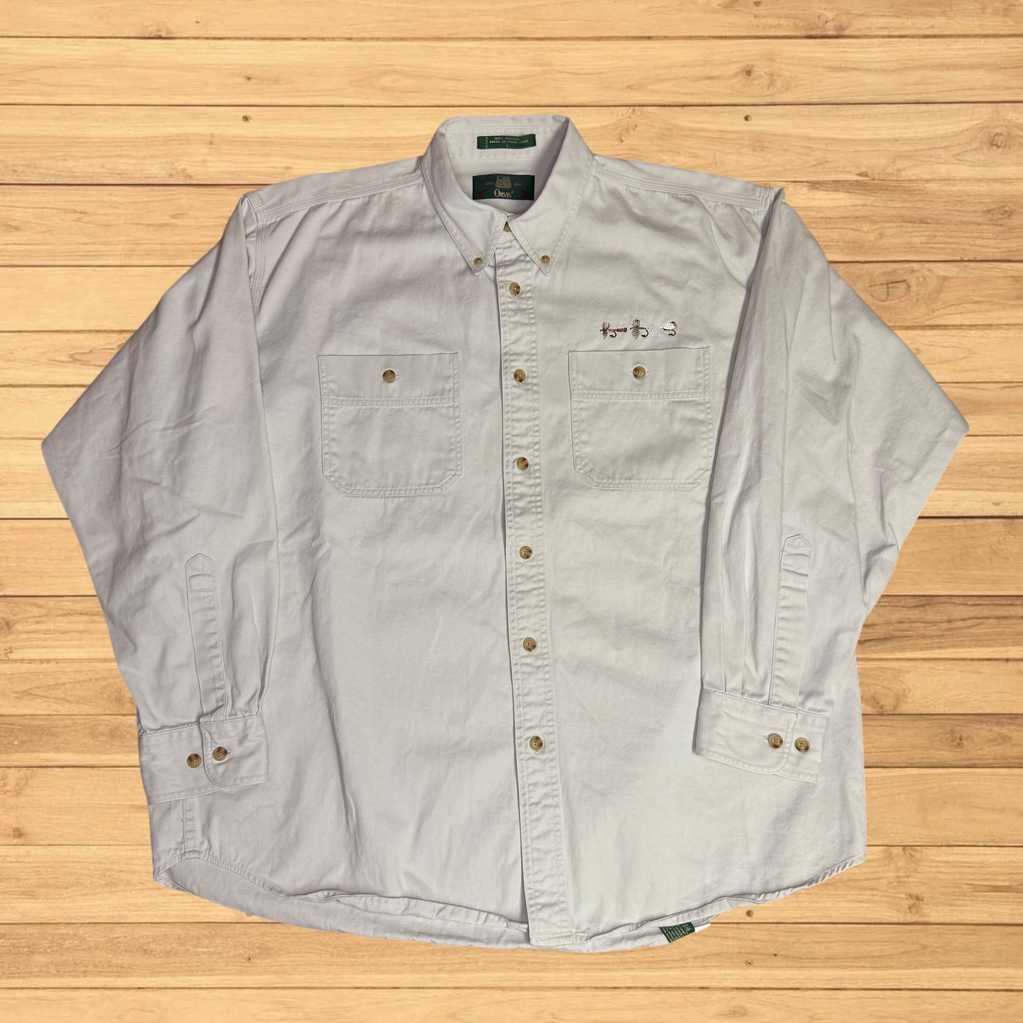 Light gray button-up shirt on a wooden surface