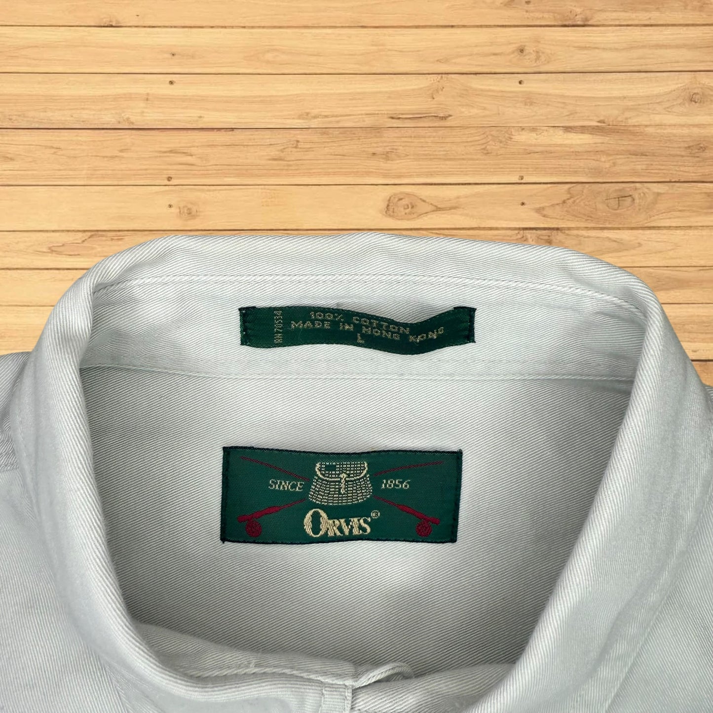 Close-up of a shirt collar with Orvis label on a wooden surface